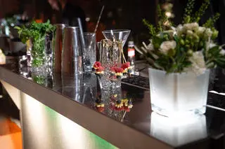 tation cocktail décorée avec fleurs fraîches, shakers et verrerie raffinée